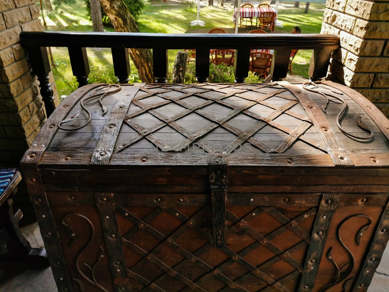 A wooden bench sitting next to a brick wall. High quality photo