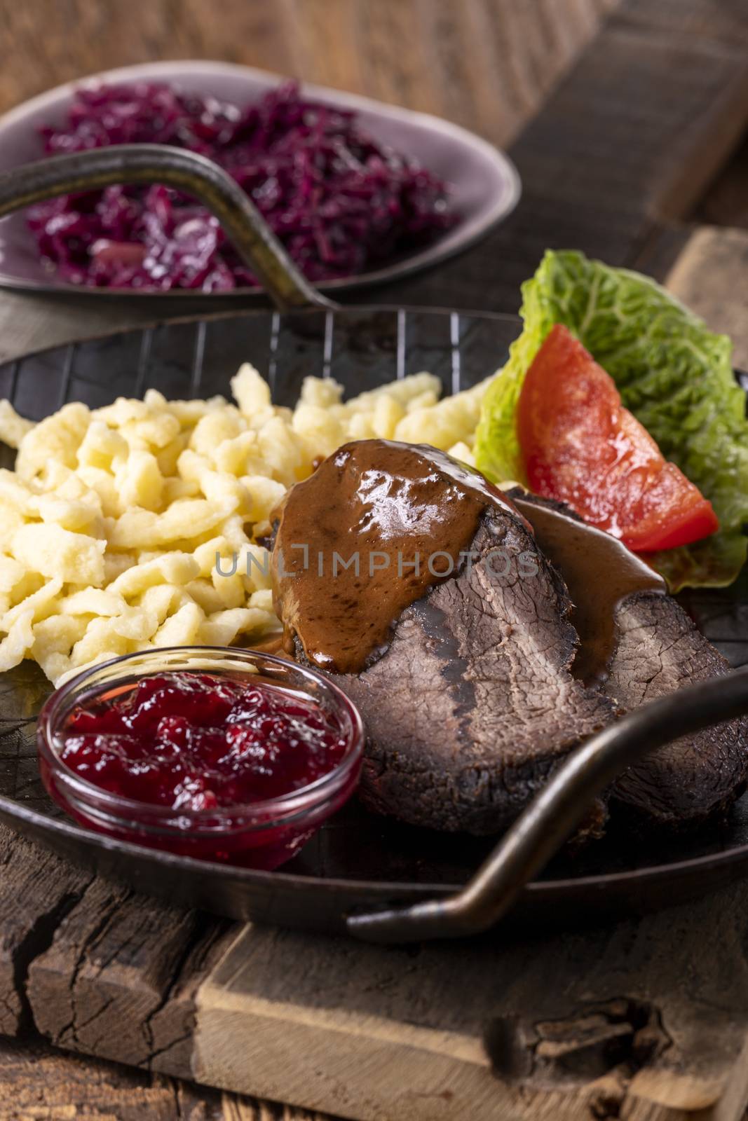 closeup of a german sauerbraten with dumplings by bernjuer