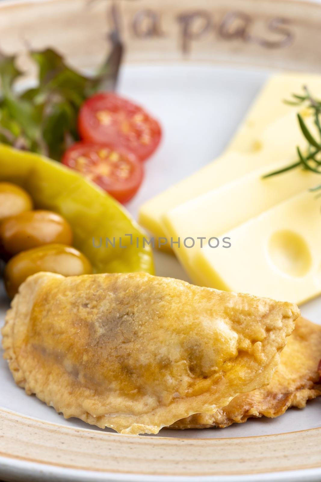 empanadas and spanish tapas on a plate by bernjuer
