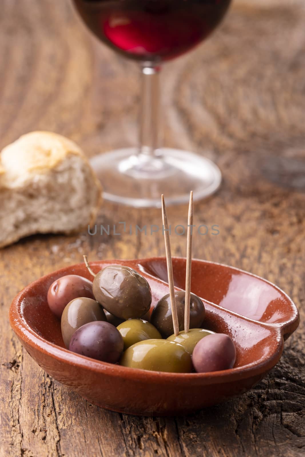 mixed olives on dark wood by bernjuer