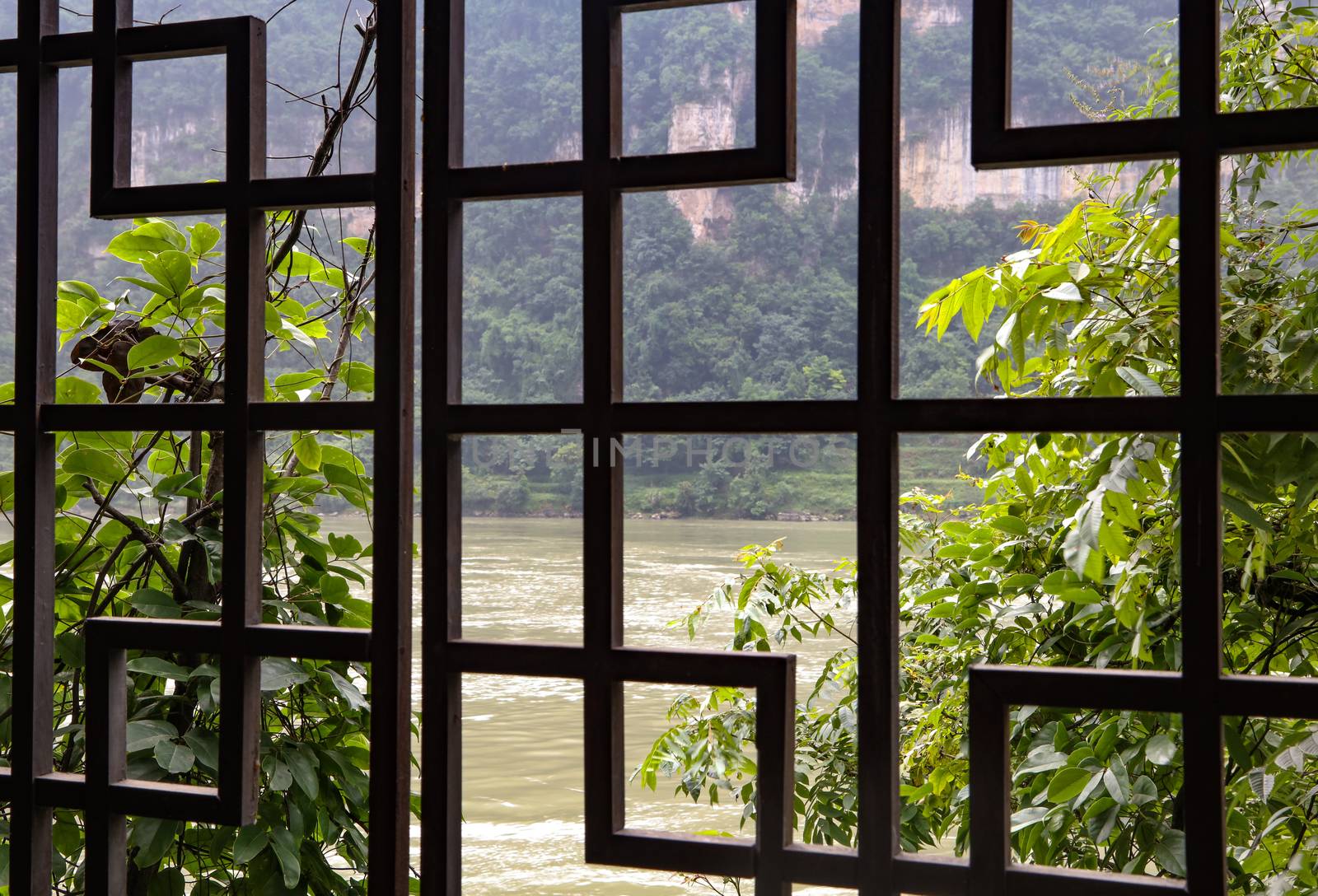 An amazing view of the Yangtze river in China from an ornate wooden window like panel.