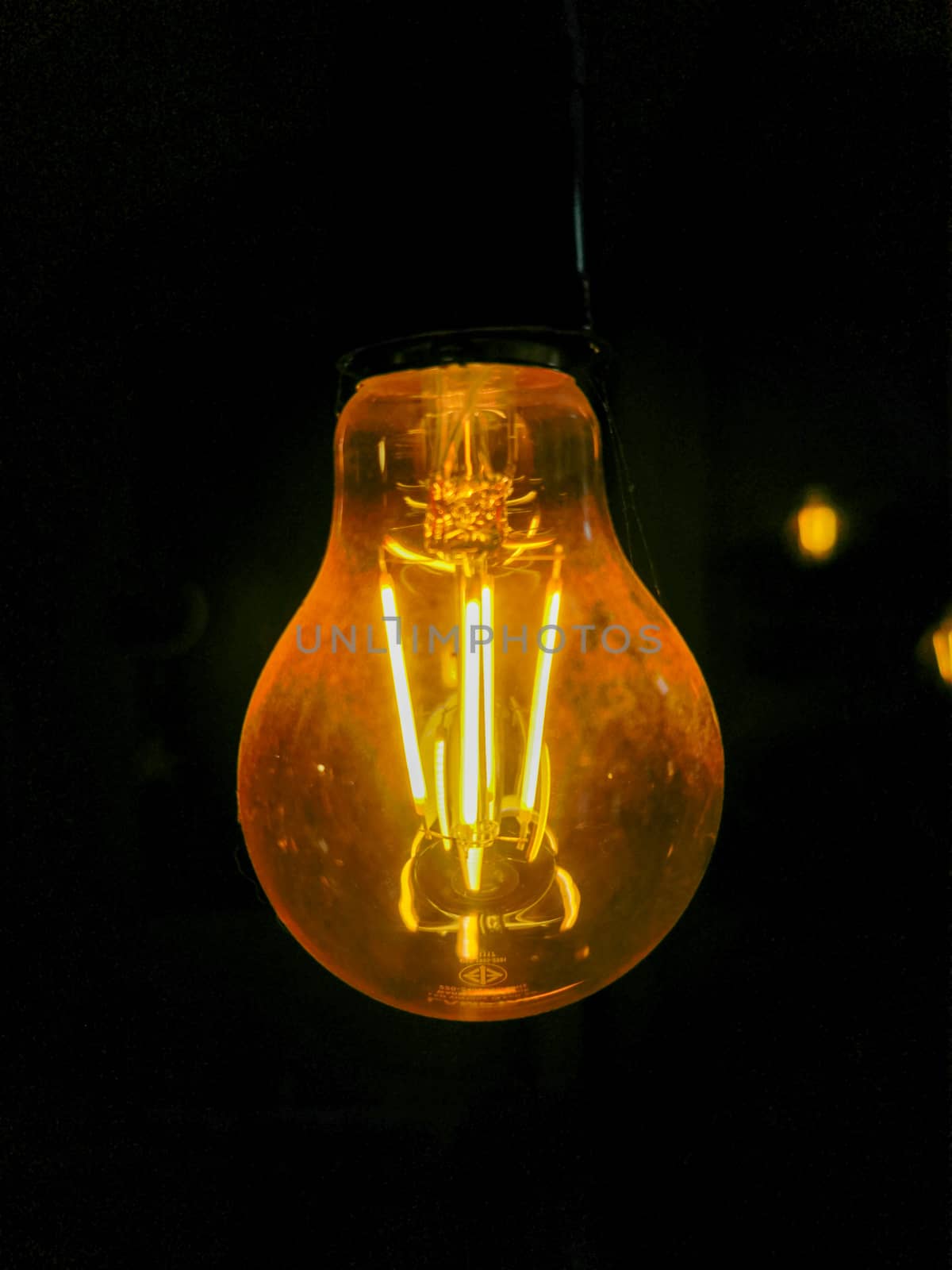 Electricity current inside a retro crystal clear light bulb.