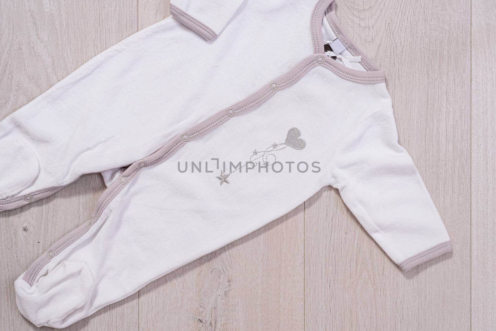 baby clothes concept. white and gray suit for boy and girl on wooden background