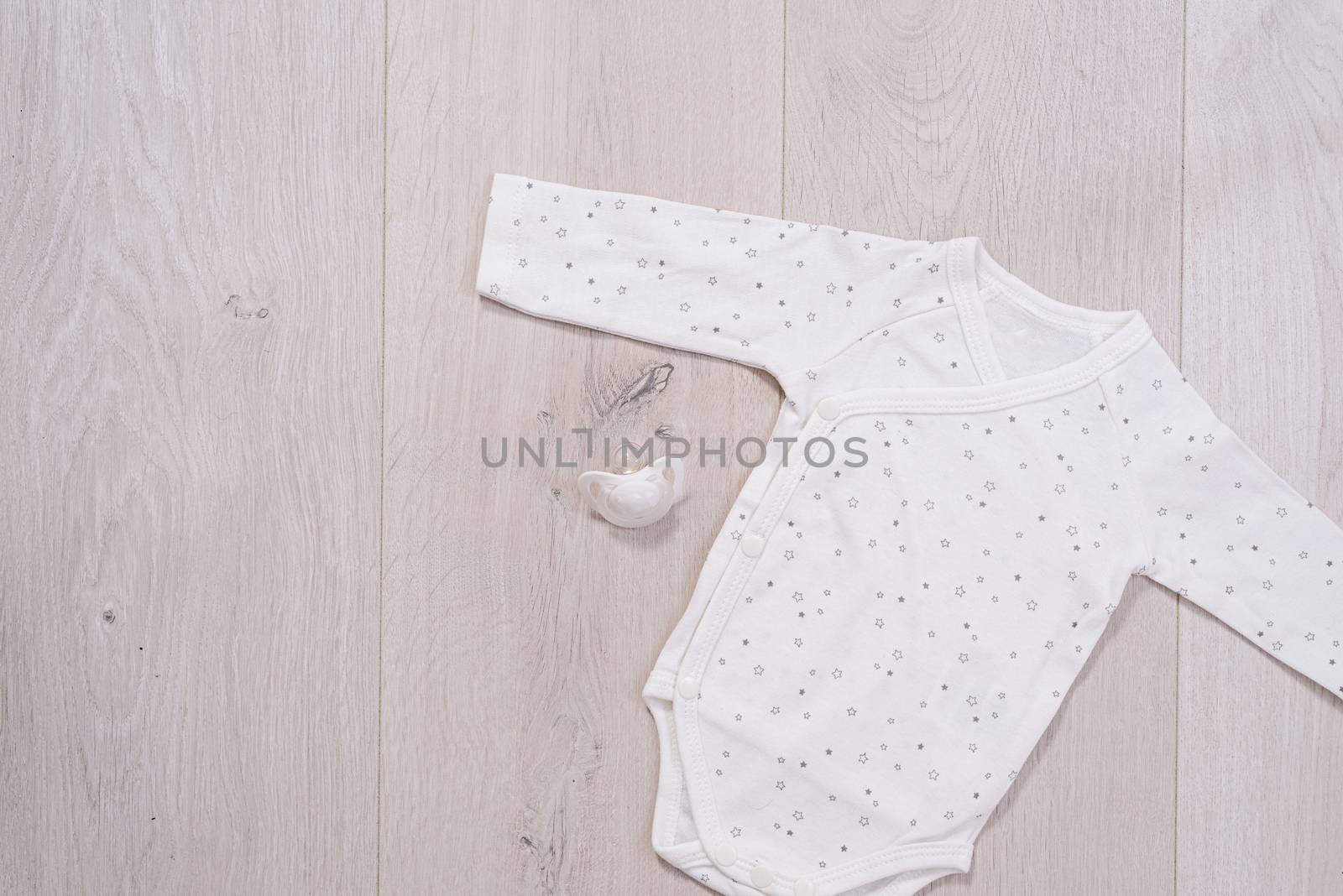baby clothes concept. white suit for boy and girl on wooden background