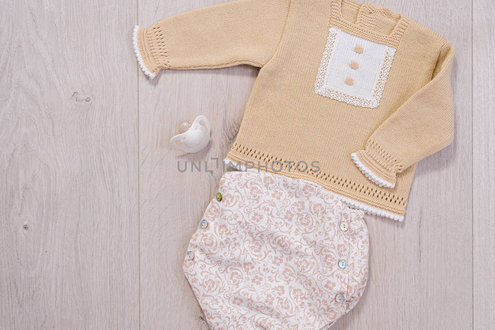 baby clothes concept. white and brown suit for boy on wooden background