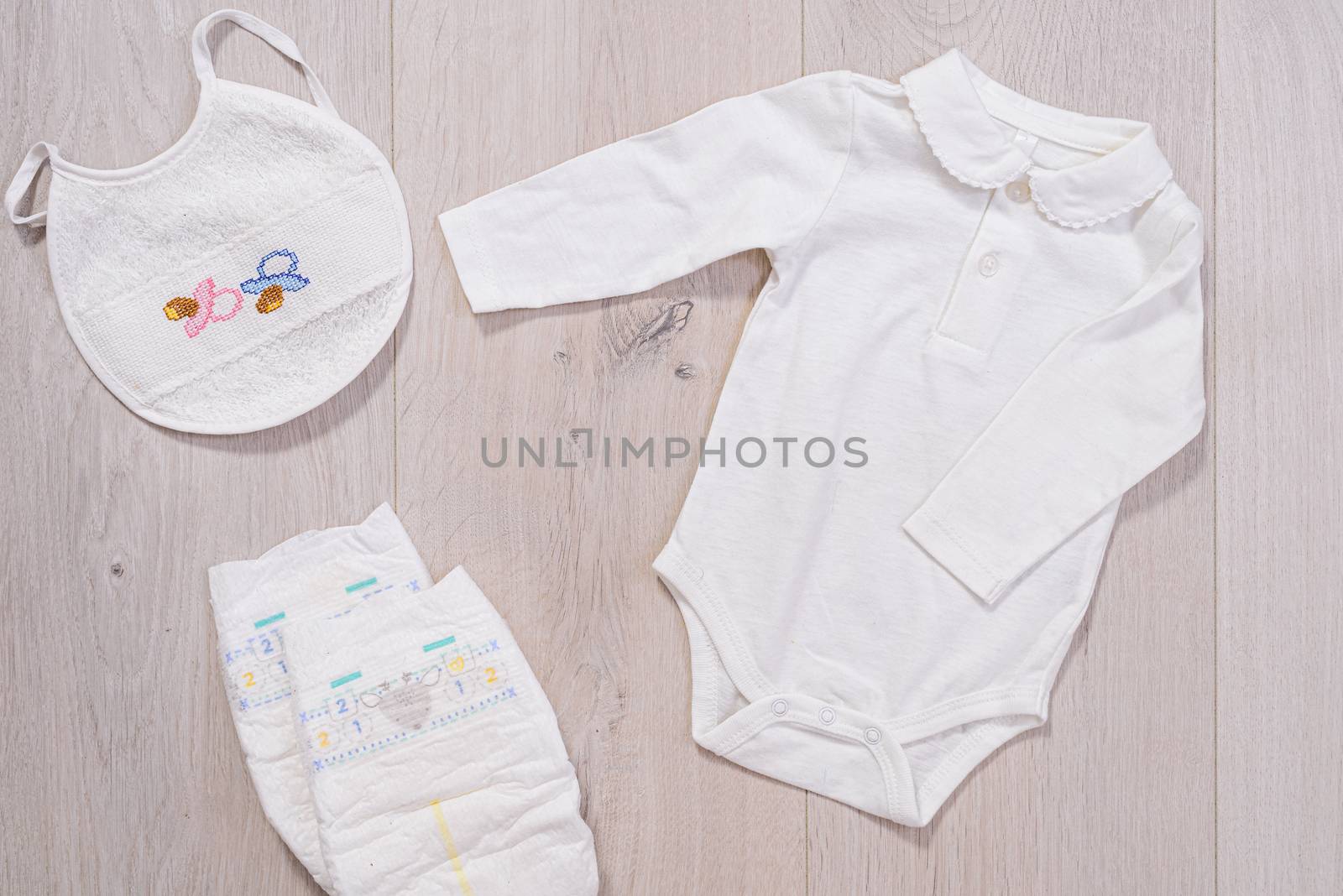White baby clothes, diapers and baby bib. newborn by jcdiazhidalgo