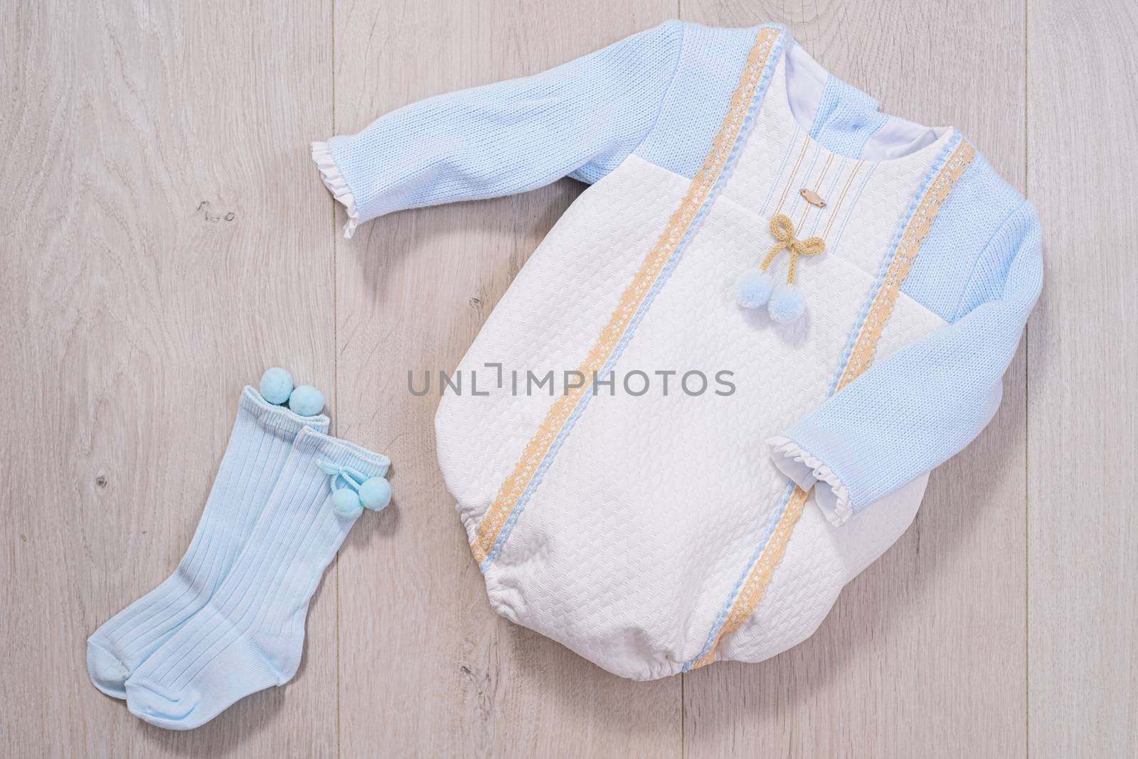 baby clothes concept. white and blue suit for boy on wooden background