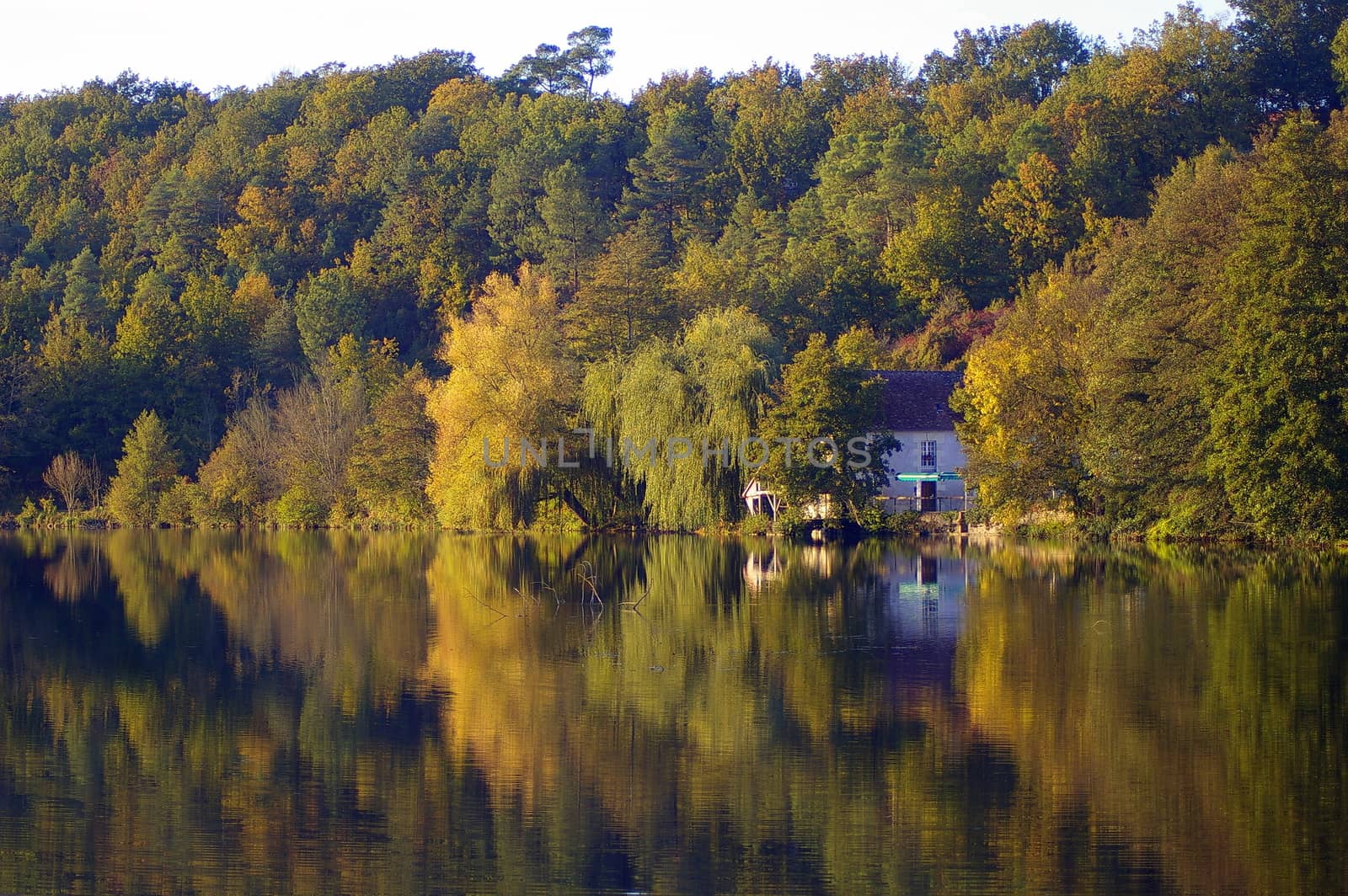 Restaurant on the Indrois river in France, with reflection of the trees in the water