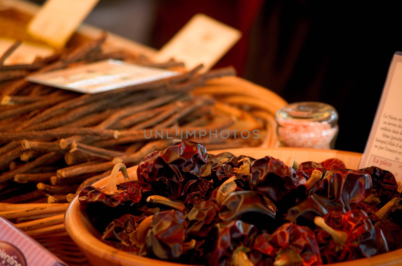 Dried peppers with liquorice root in the background on a market stall, France