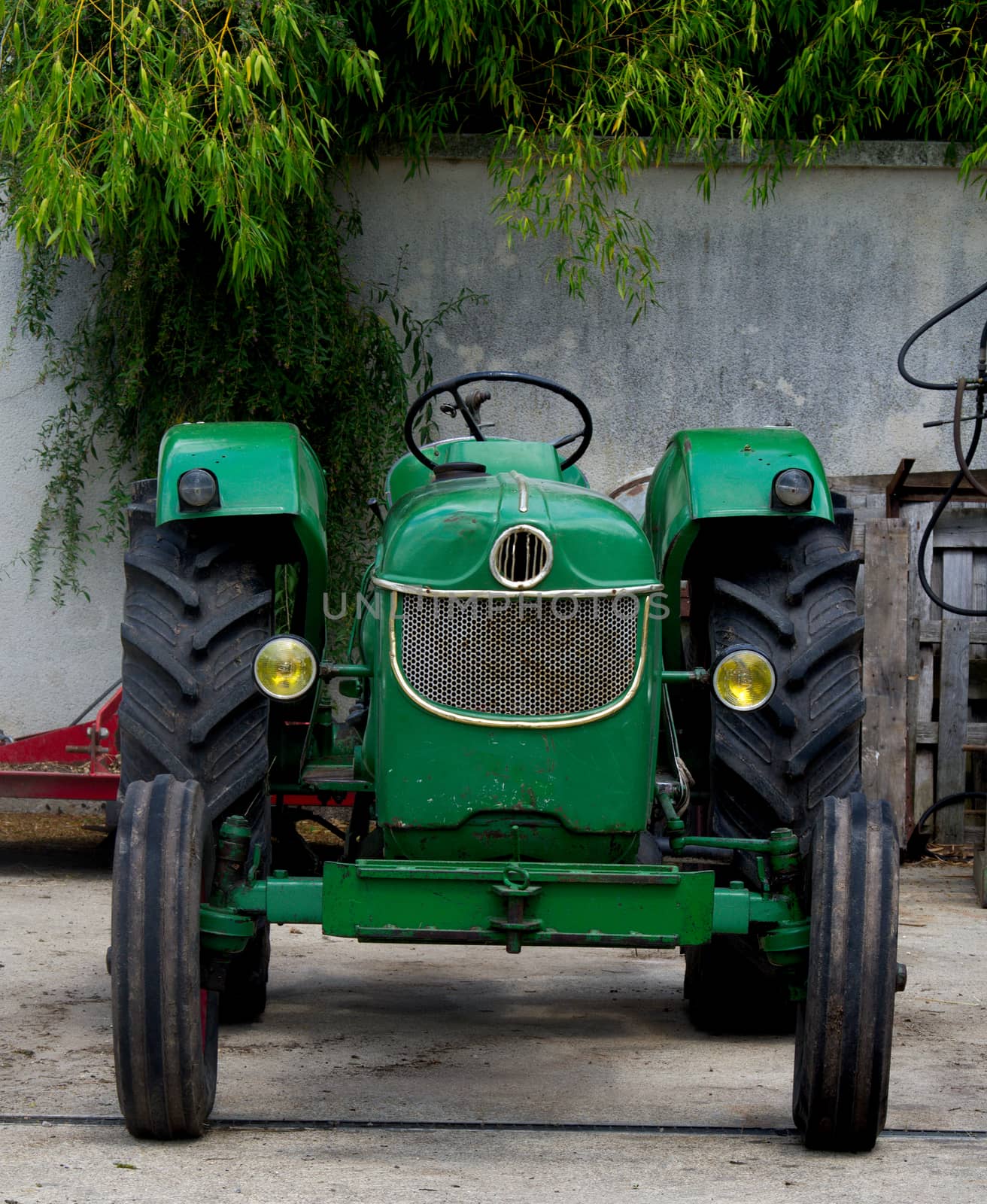 Old parked green tractor in France