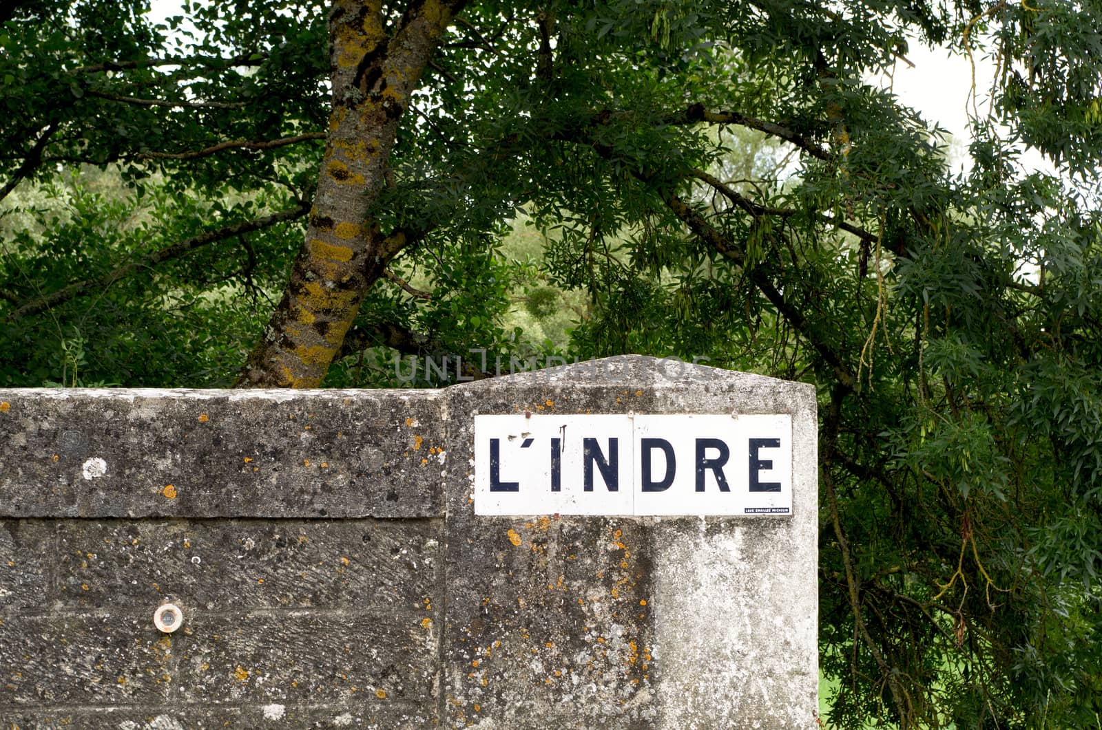 River name on a sign painted on a stone bridge over indicated River Indre, France