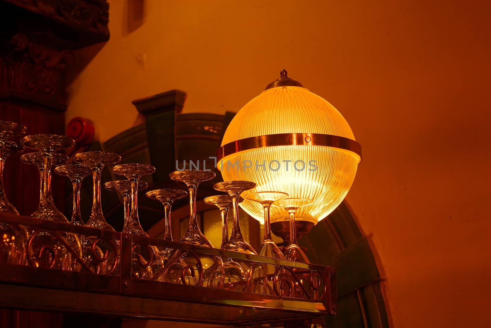 Lit bar interior featuring upturned glasses and a light