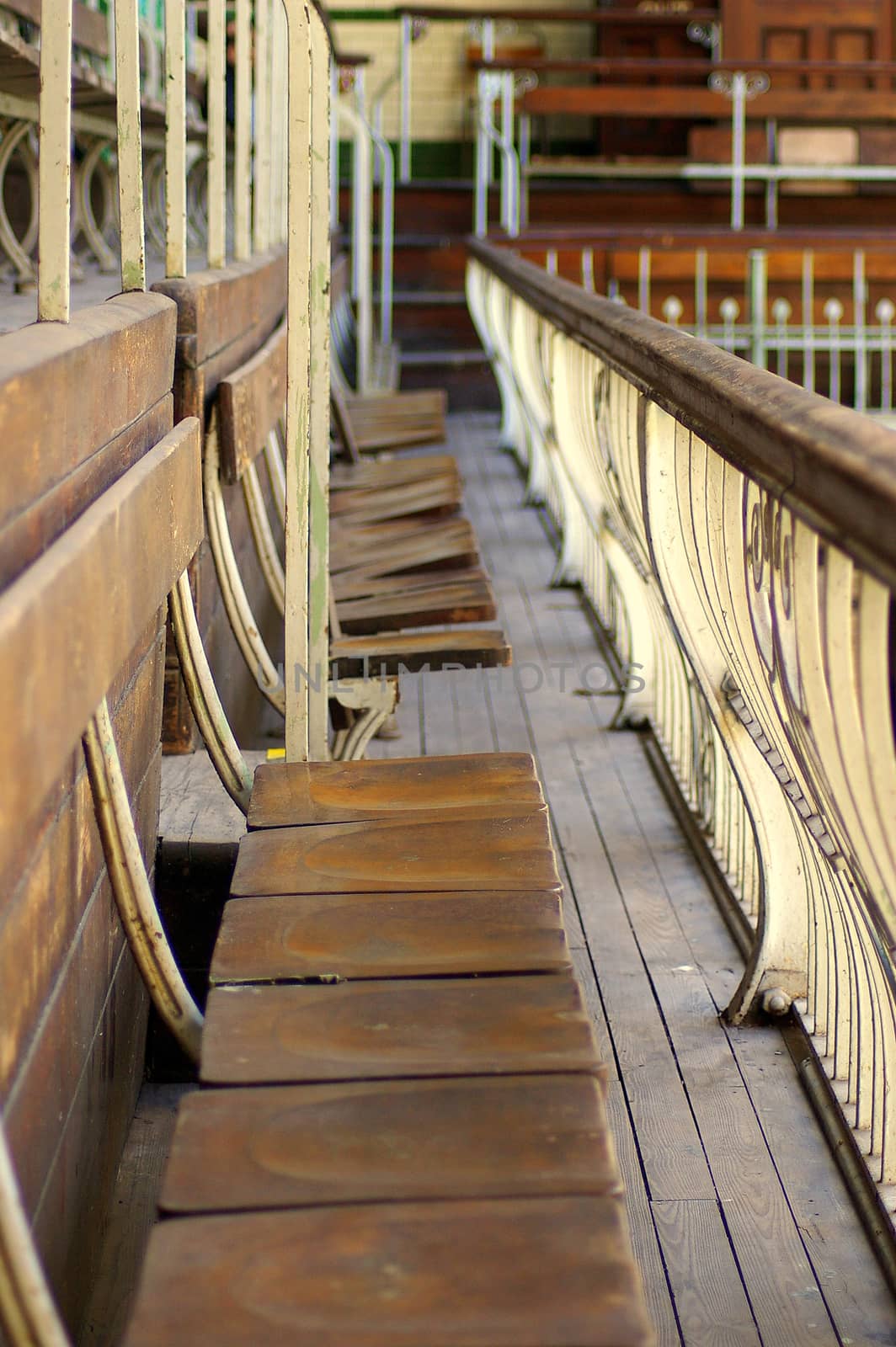 Row of old wooden seats and safety railing