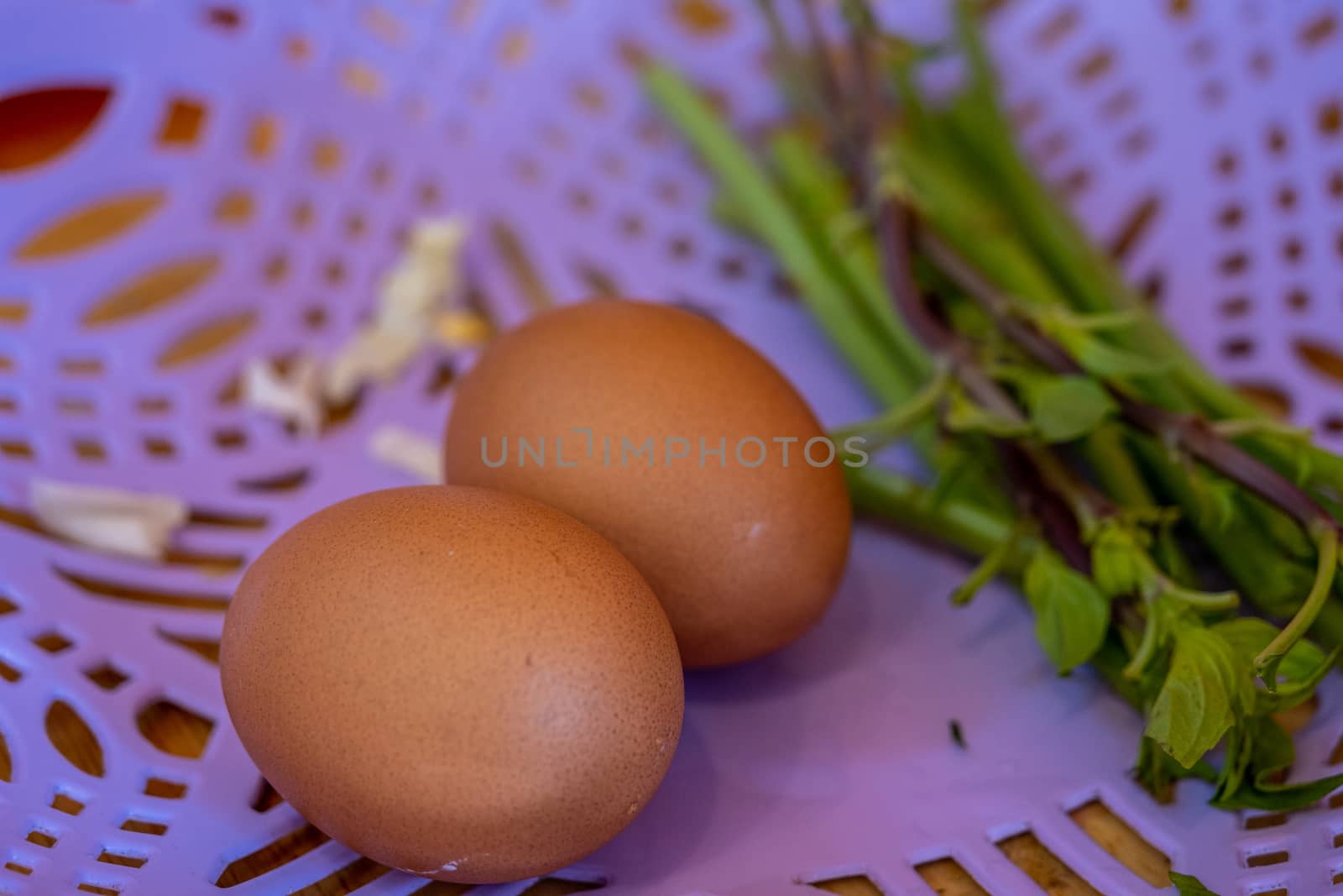 Two chicken eggs in the purple basket for cooking. by peerapixs