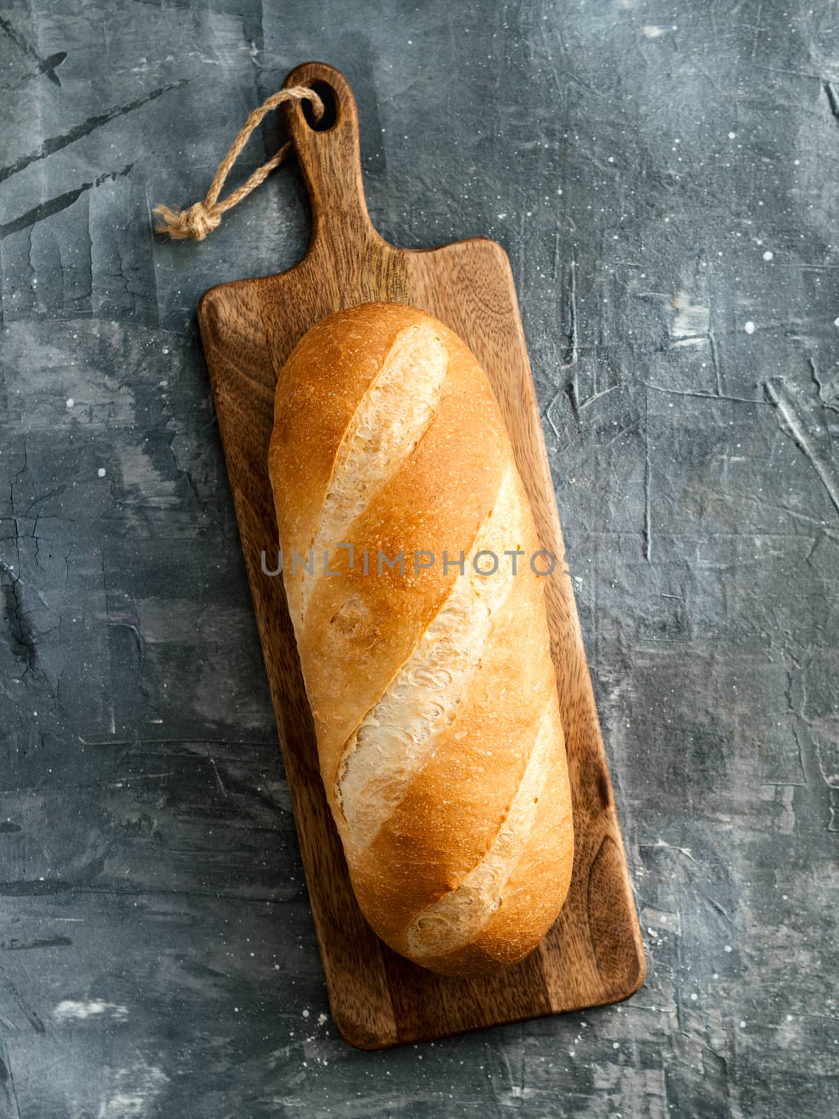 British White Bloomer or European Baton loaf bread on gray background. Top view or flat lay. Copy space for text or design. Vertical.