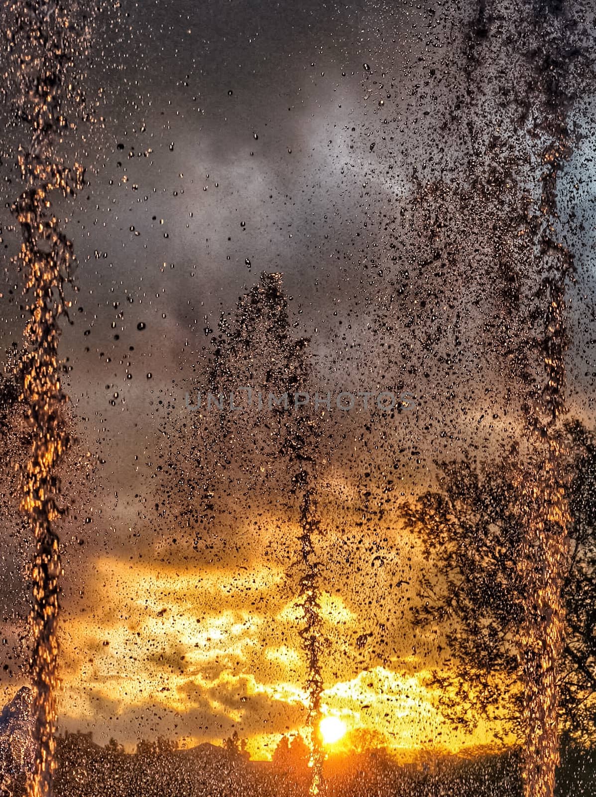 Beautiful spray of a fountain against the sky with sunset.