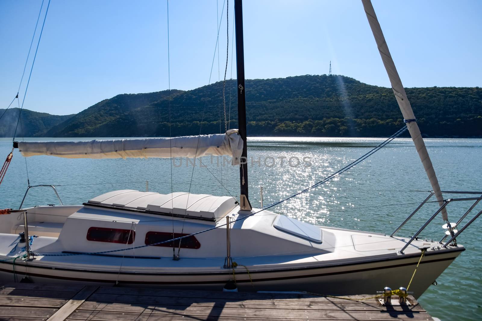 Yacht on pier near the shore on the lake. by fedoseevaolga