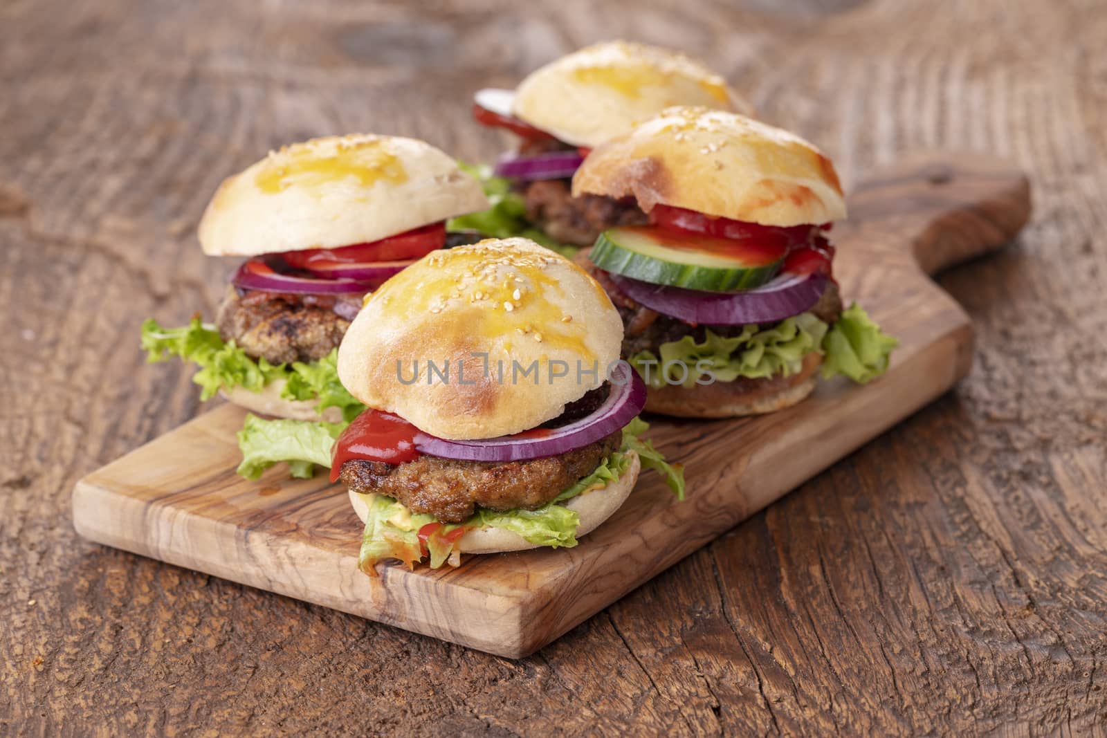 four small hamburges on a board