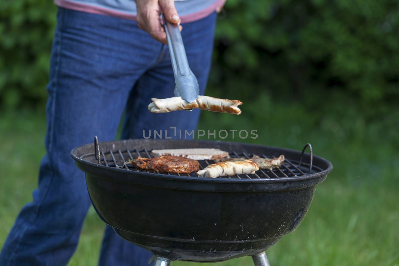 man holding a sausage at the bbq by bernjuer