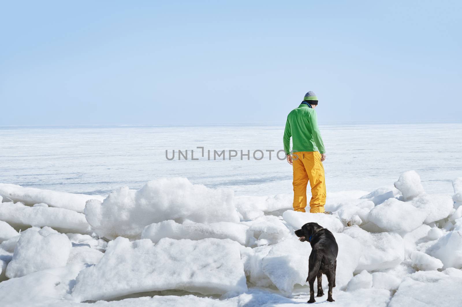 Young adult man outdoors with his dog exploring winter landscape by Novic