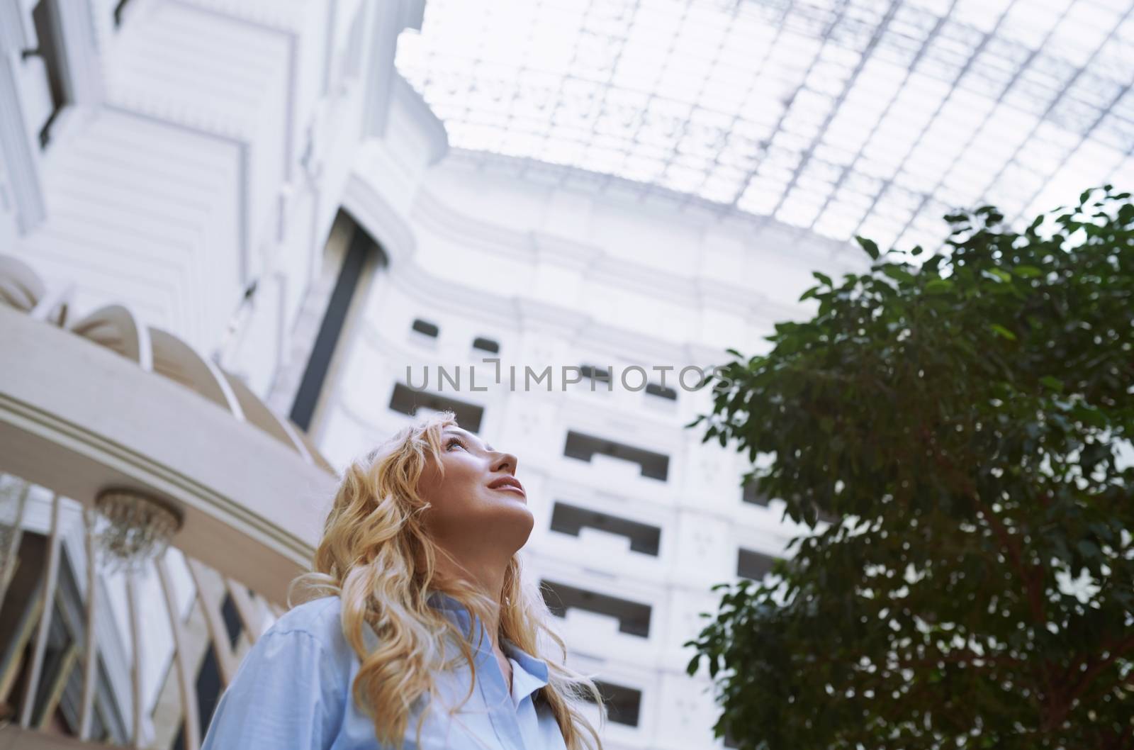 Businesswoman in the modern bank lobby looking up