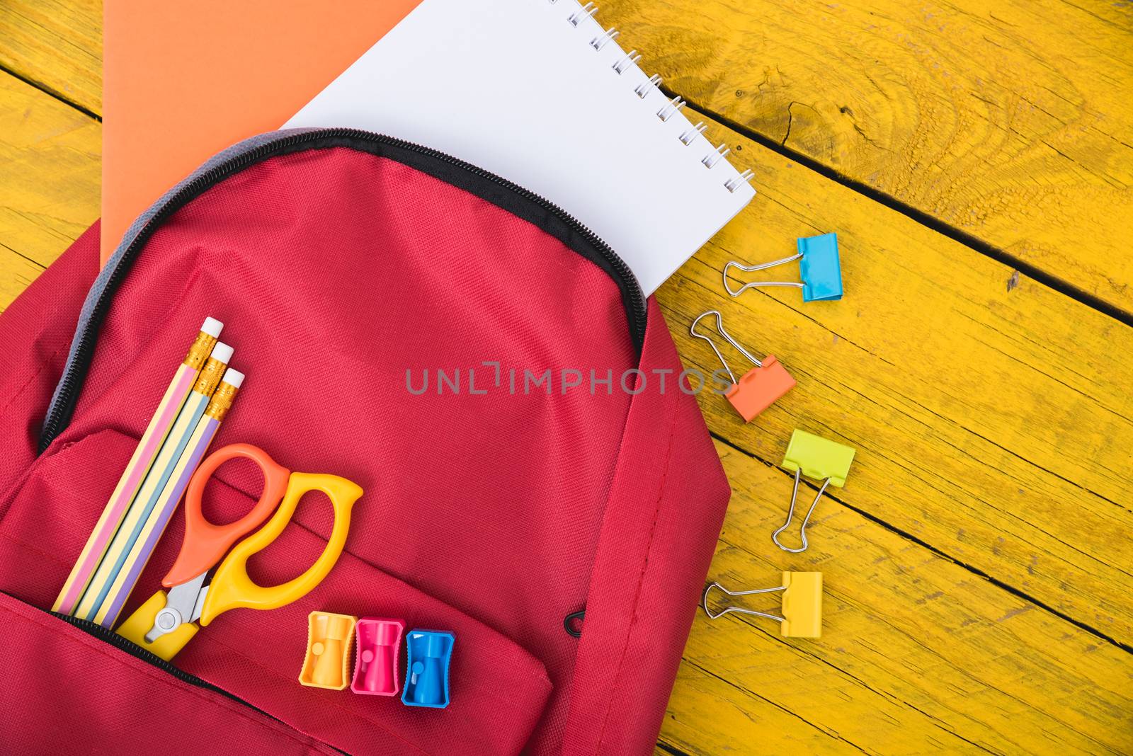 Top view Red bag backpack for education children on yellow wooden  background back to school concept