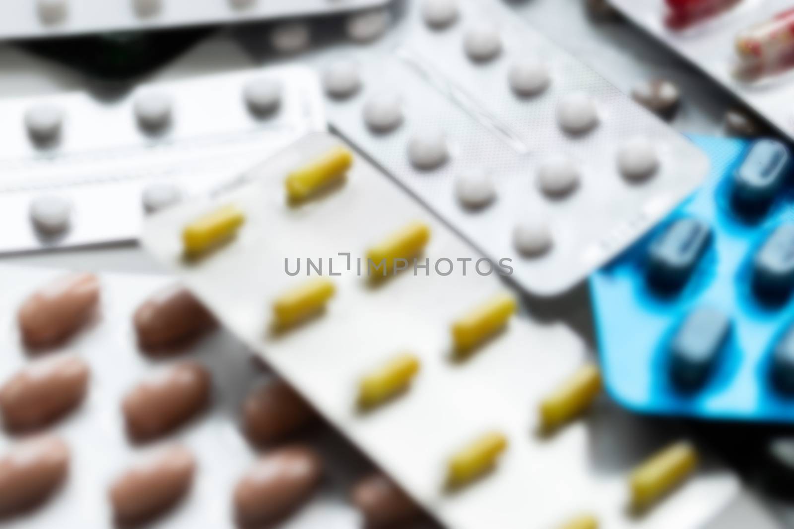 Vitamins and tablets in blister packs, close-up. Blurred background, place to insert text. Modern healthcare and pharmacy.