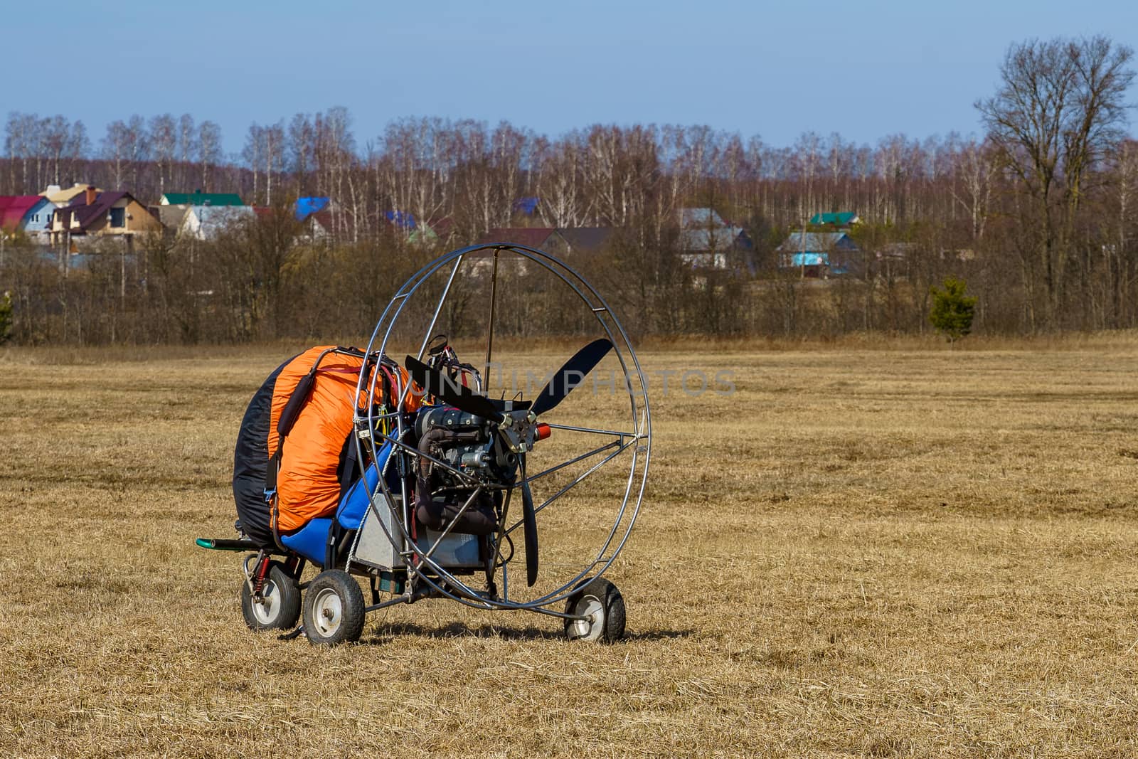 paraglider stands on the field on a sunny day prepared for flight