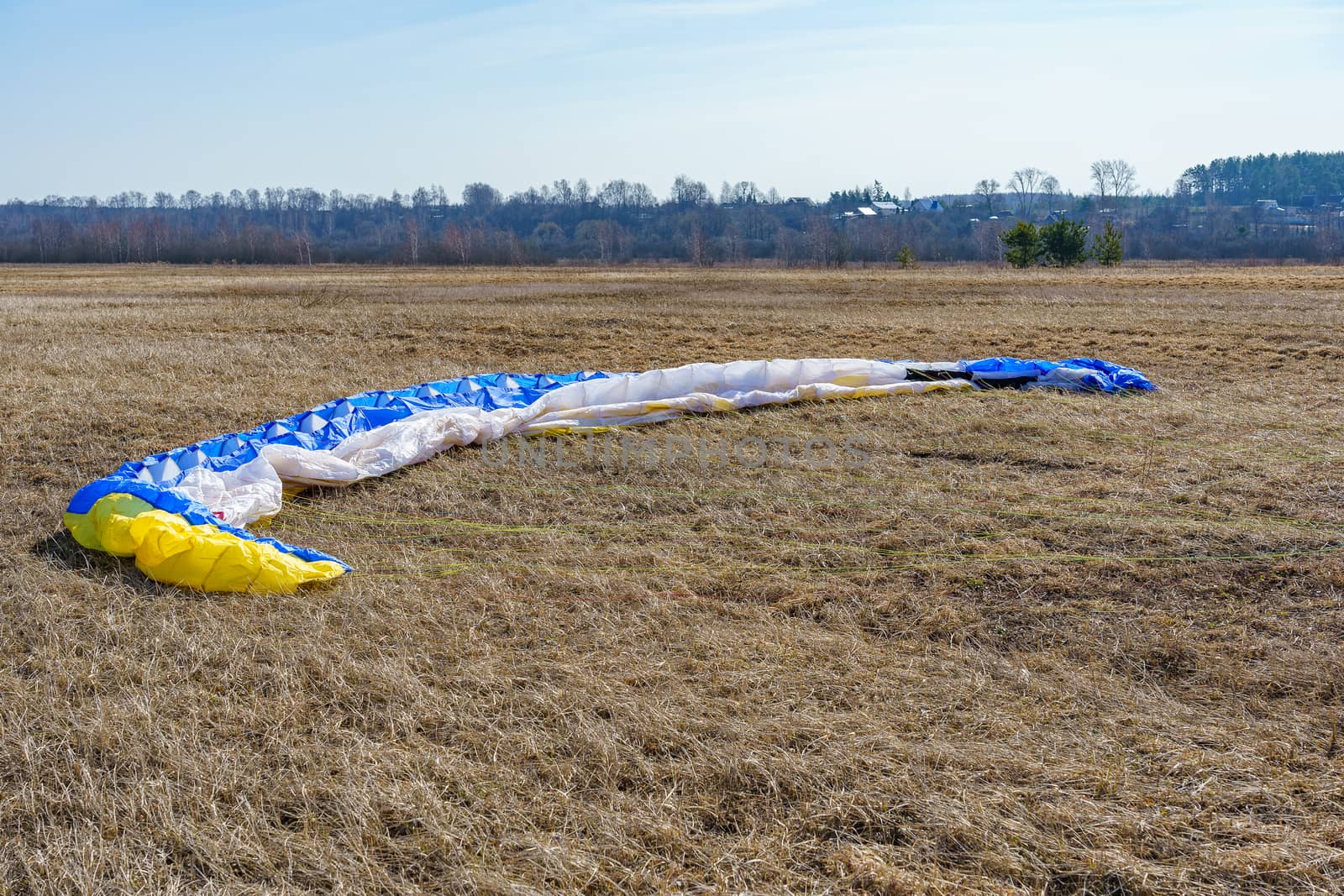 parachute spread on dry grass on the field on a sunny day by VADIM