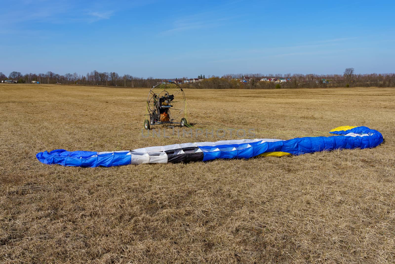 the parachute is spread on the dry grass on the field on a sunny day by VADIM