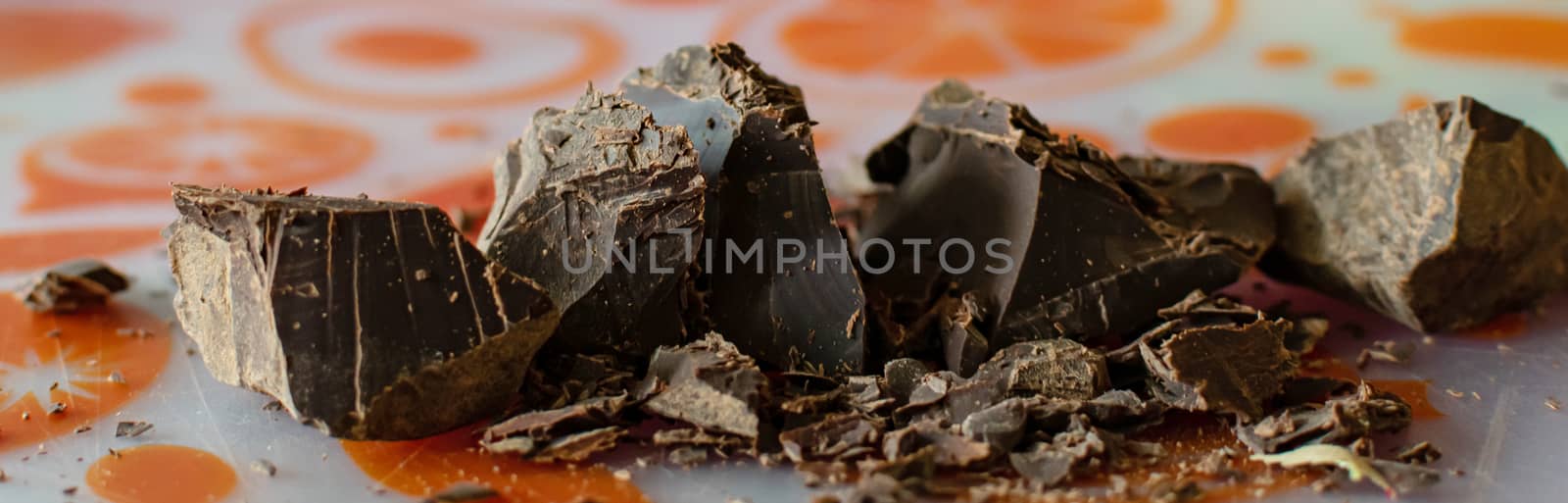 Cocoa paste or mass-Theobroma cocoa. Broken pieces of chocolate Ingredients for making sweets. Close up.