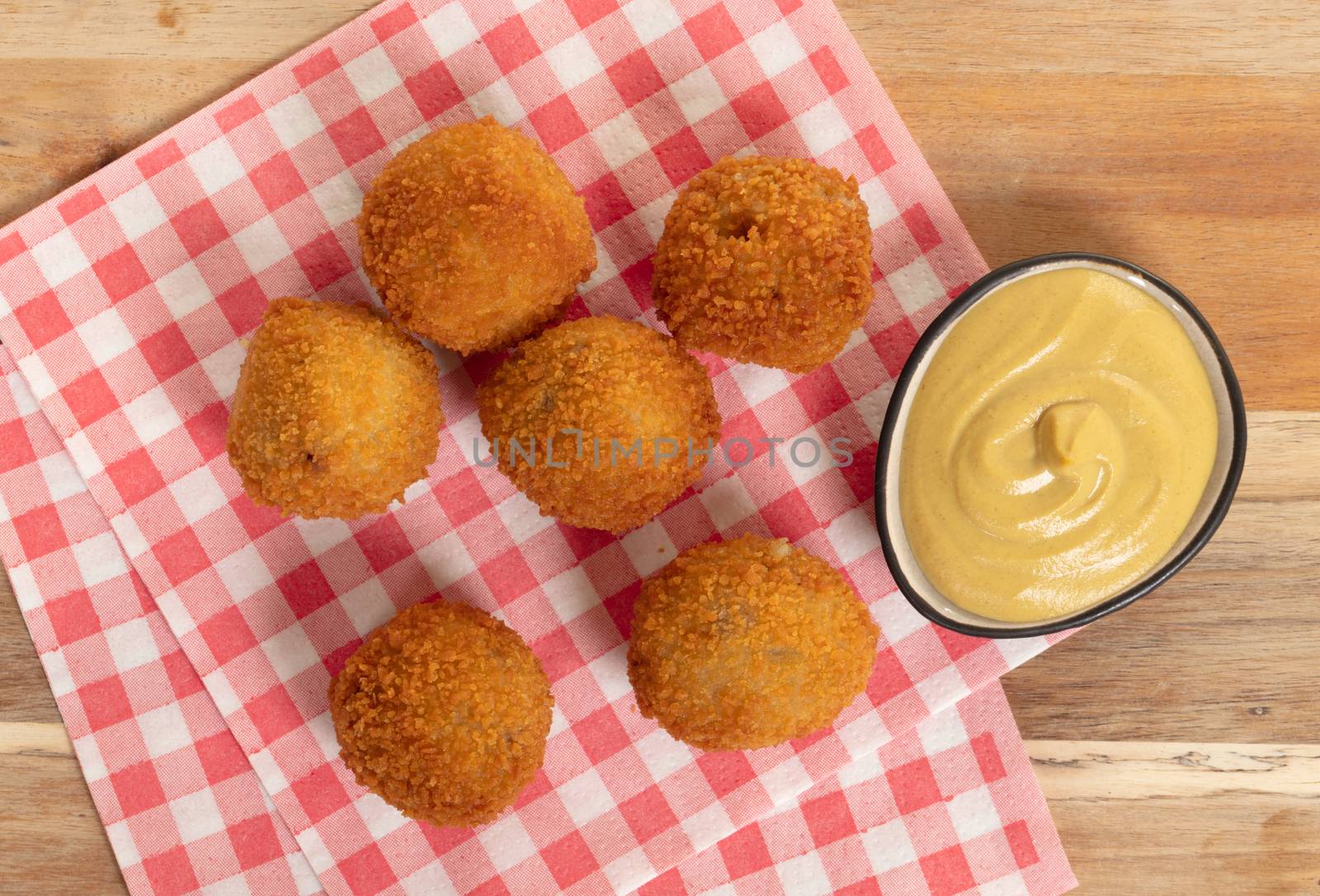 Dutch traditional snack bitterbal on a serving board by michaklootwijk