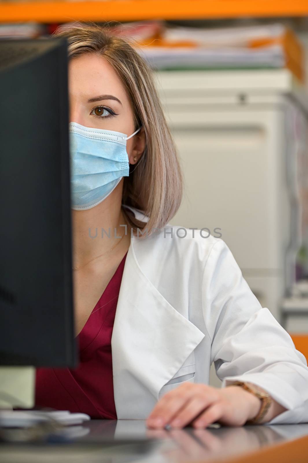 Doctor In A Mask Works On A Computer by mady70