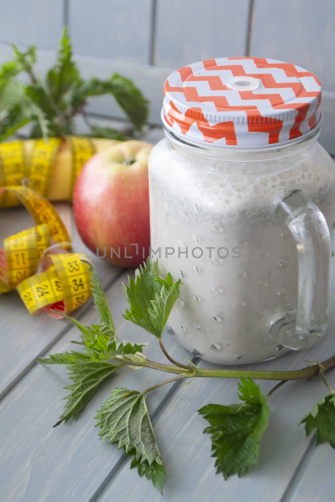 smoothie with apples, bananas, nettle. Organic diet, healthy lifestyle concept. Tape mesure. Vertical image