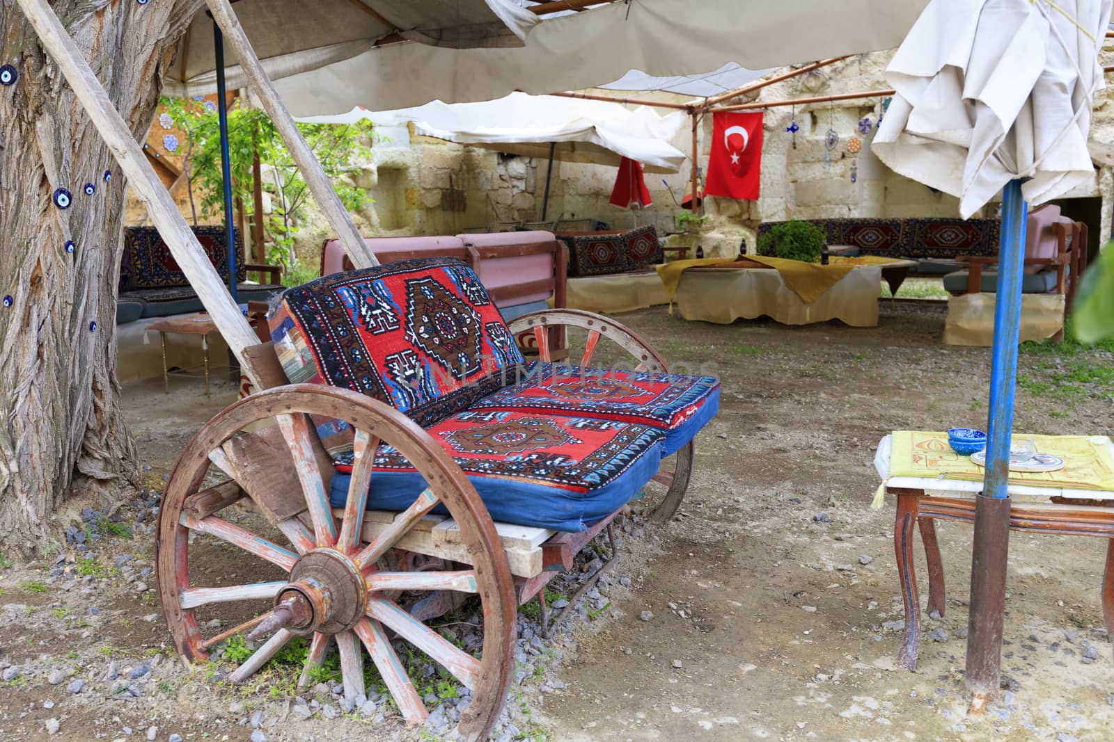 Old wooden cart as a soft chair at a table in the courtyard of the Turkish yard. by Sergii