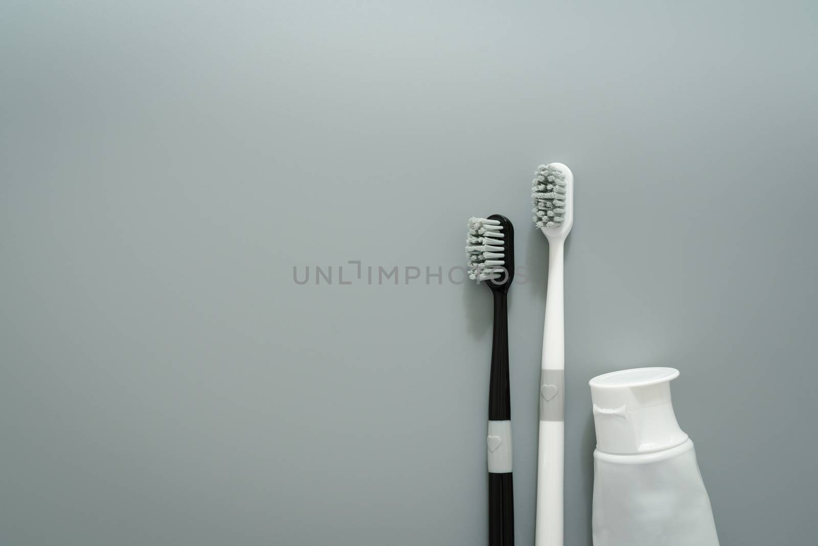 couple of toothbrush with toothpaste on gray background, healthc by psodaz