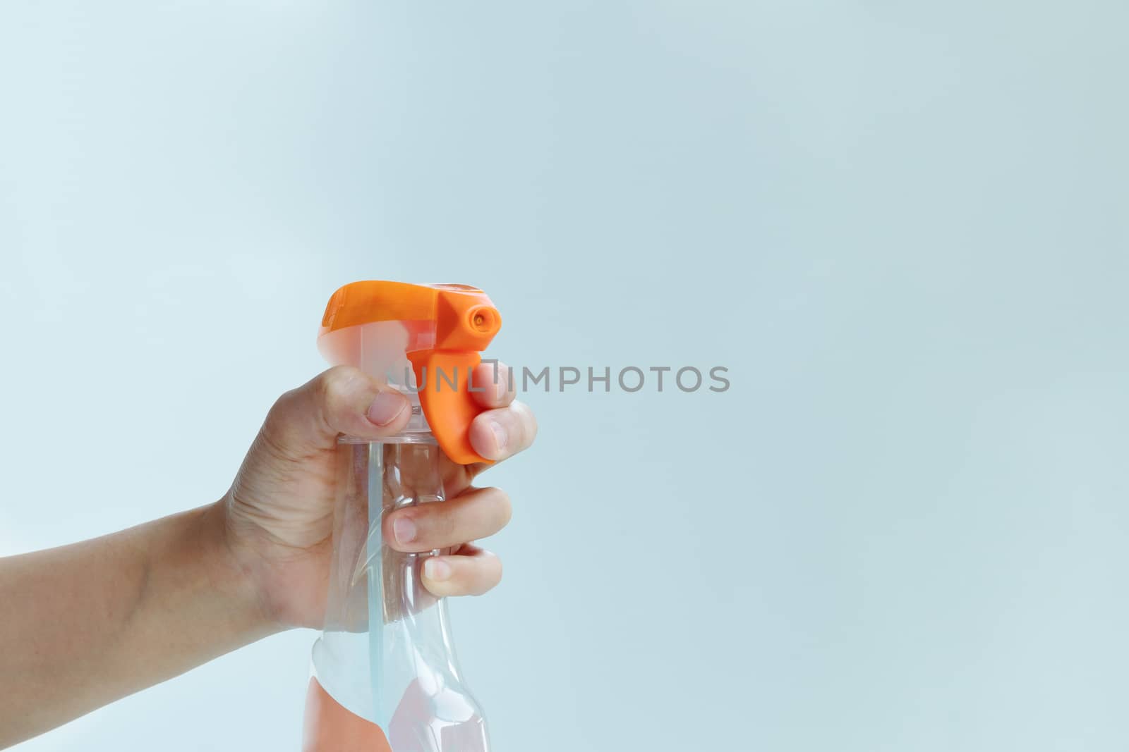 woman hand hold a spray of cleaning fluid on blue background