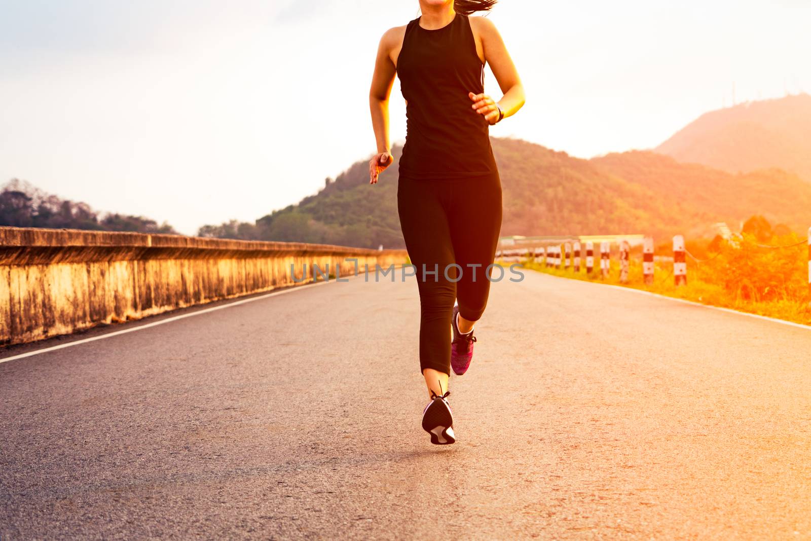 sport woman running on a road. Fitness woman training at sunset