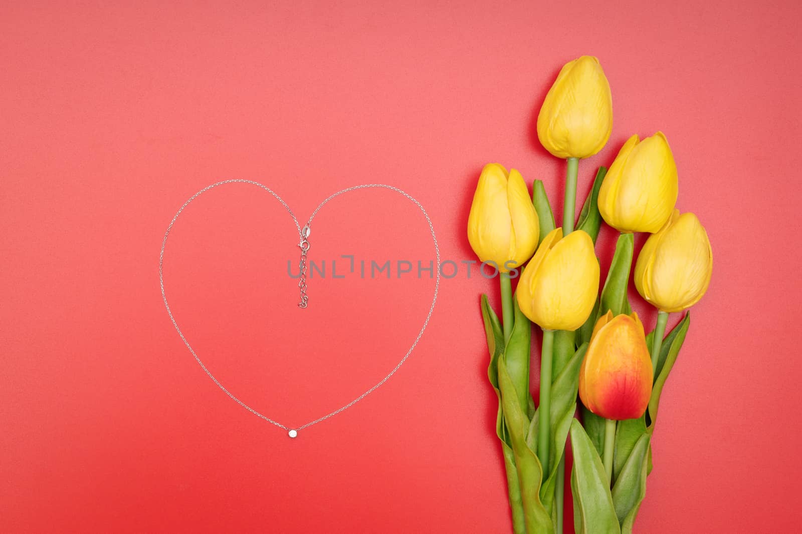 International Womens Day with flowers and heart shape necklace on red background