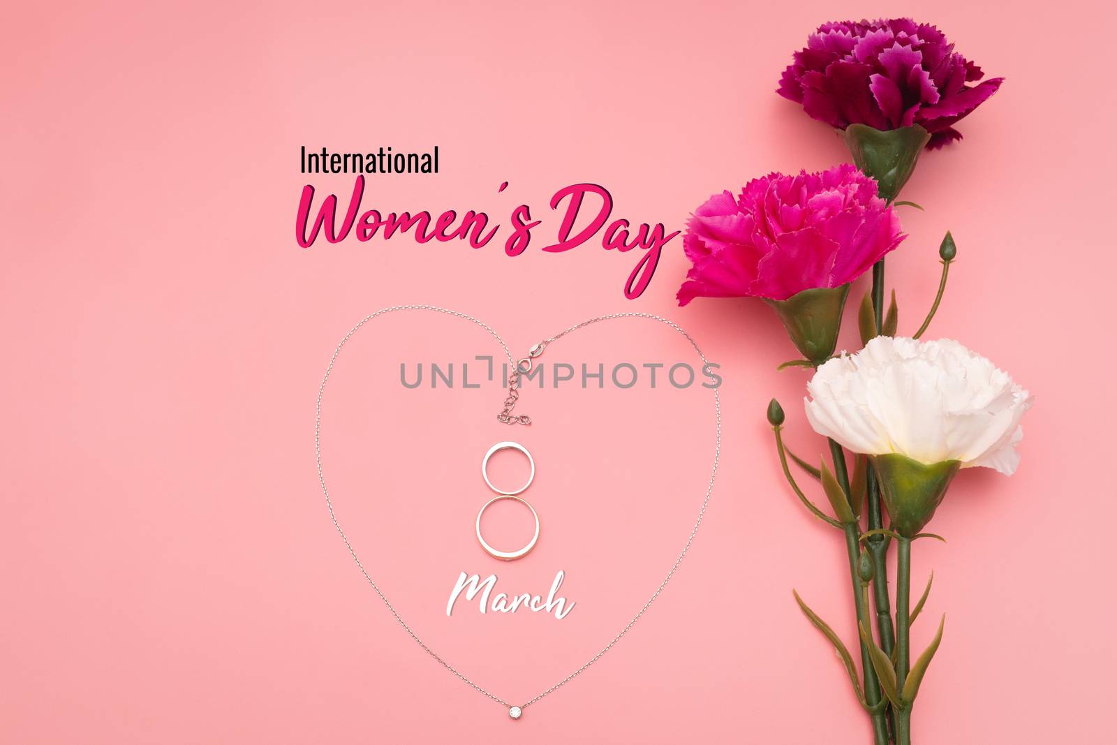International Womens Day with flowers and heart shape necklace on pink background