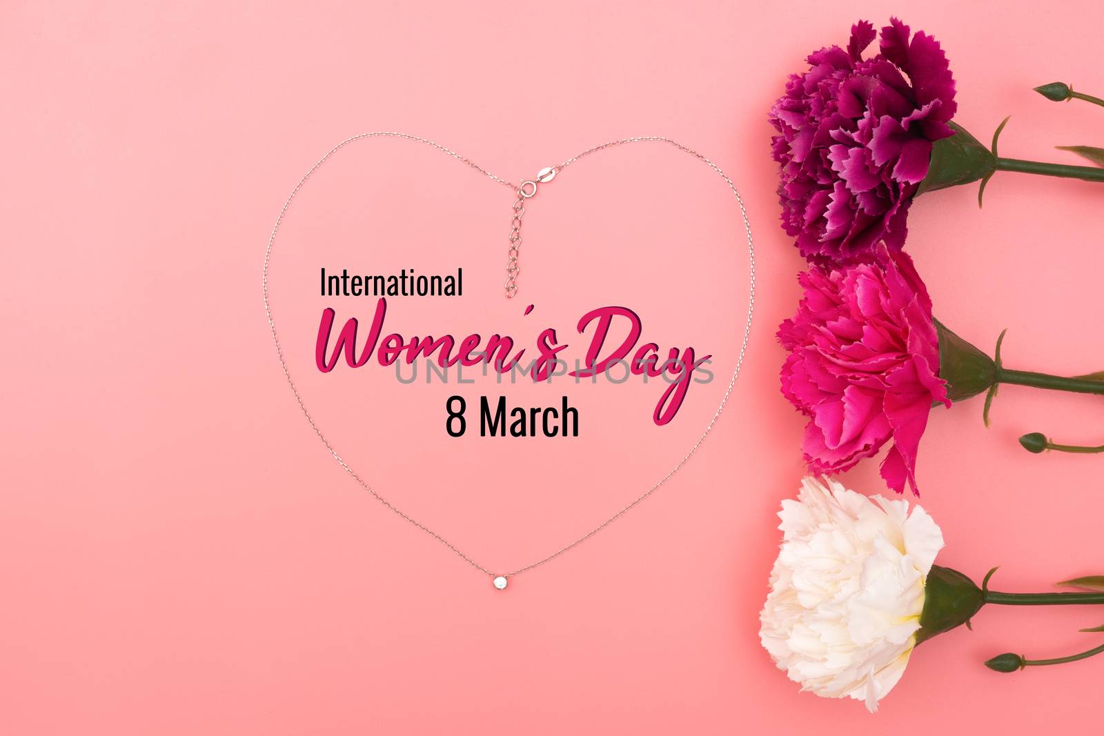 International Womens Day with flowers and heart shape necklace on pink background