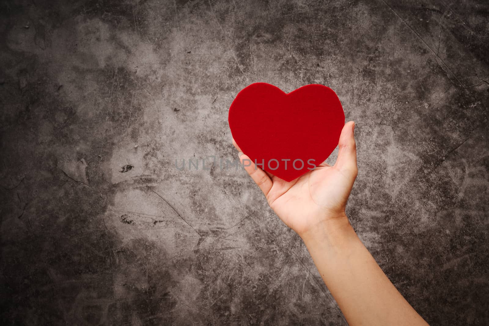 World health day, women hand hold red heart  on grunge black background