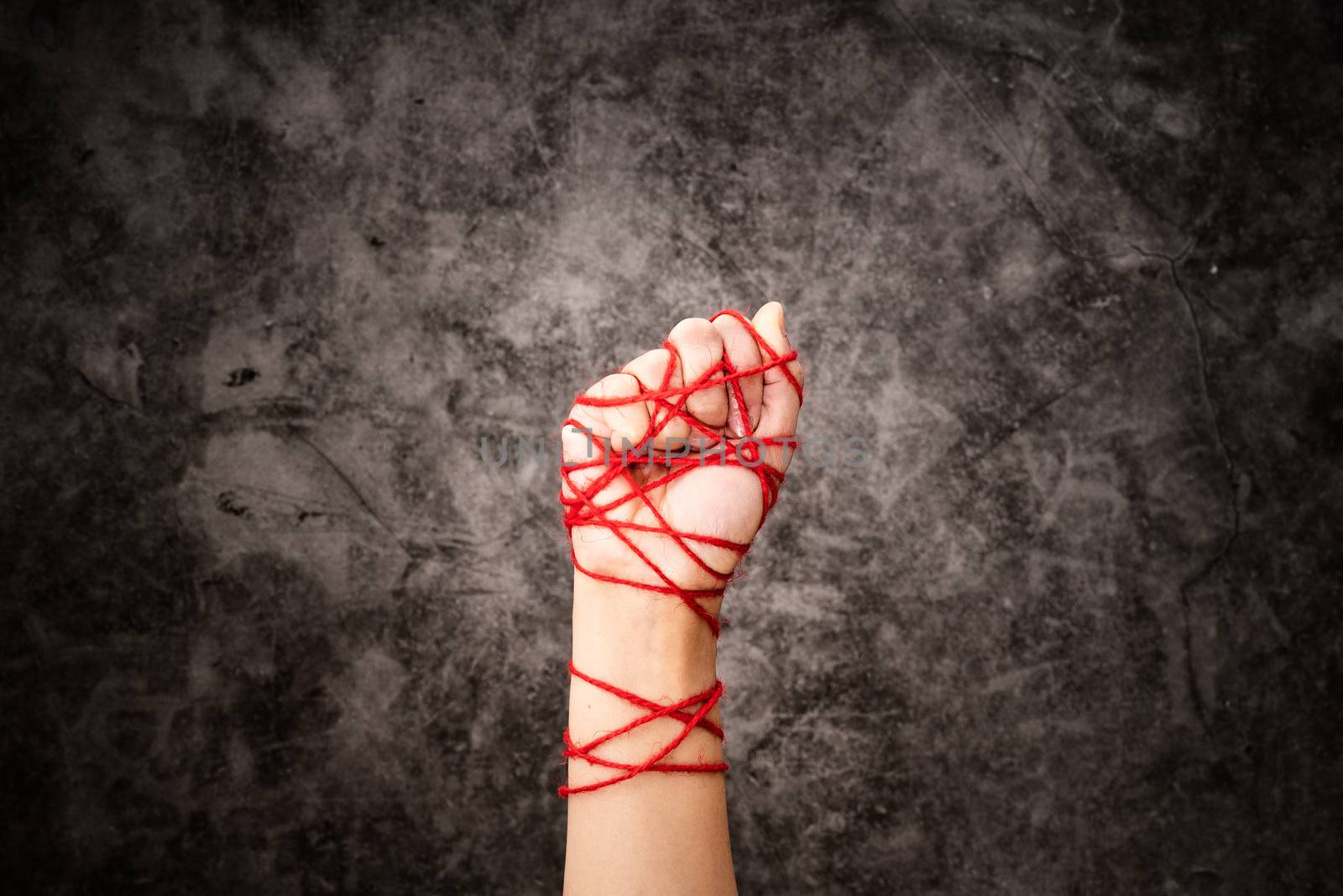 Women hand tied with rope, the idea of freedom expression on dark grunge background in low key. international human rights day concept.
