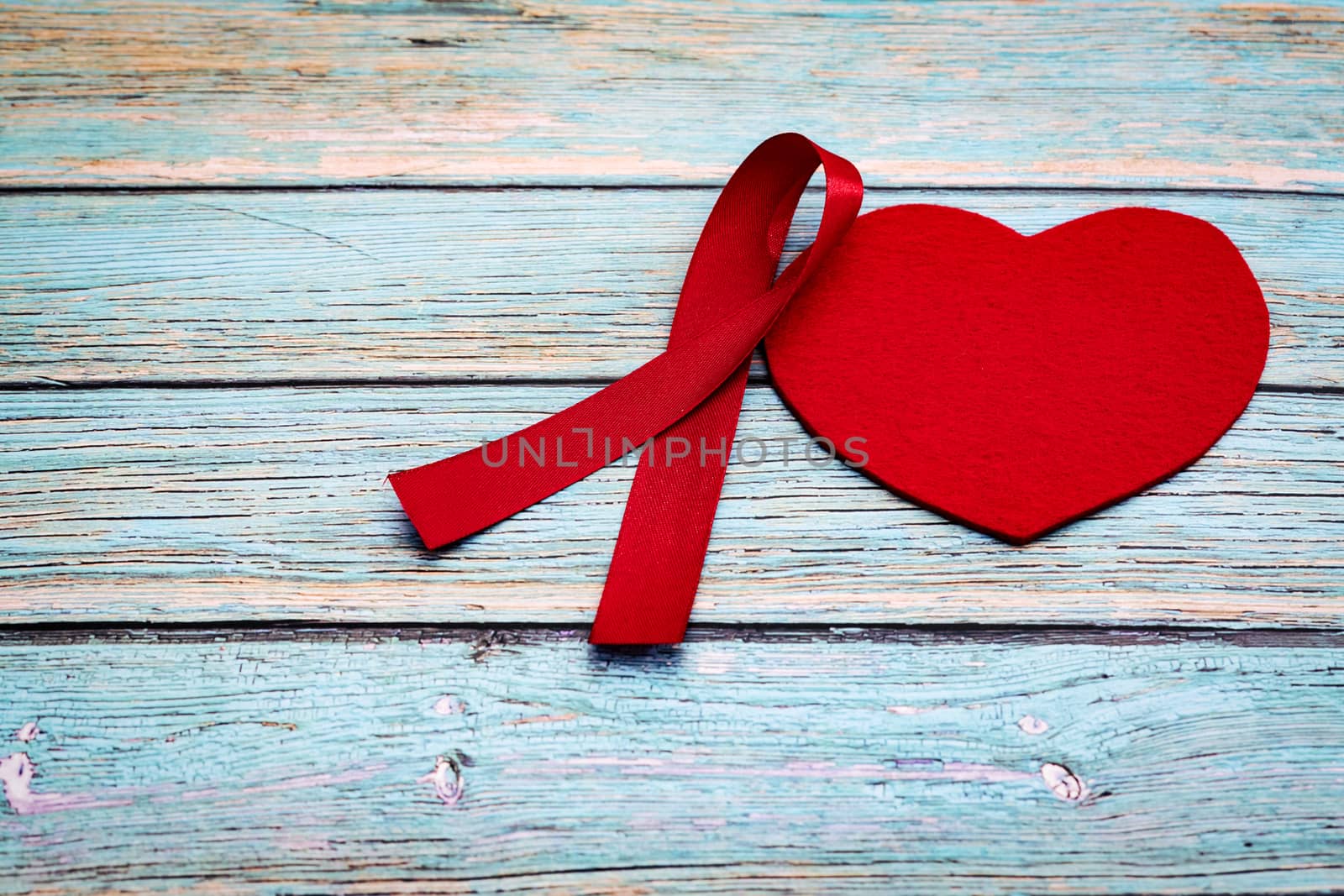 World health day, healthcare and medical concept, red ribbon and red heart on the blue wooden background