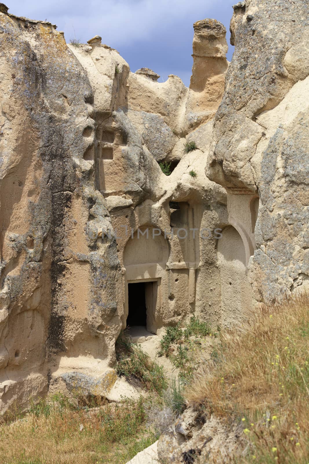 Mysterious inconspicuous entrance to the old ancient cave temple carved into the mountain valley of Cappadocia