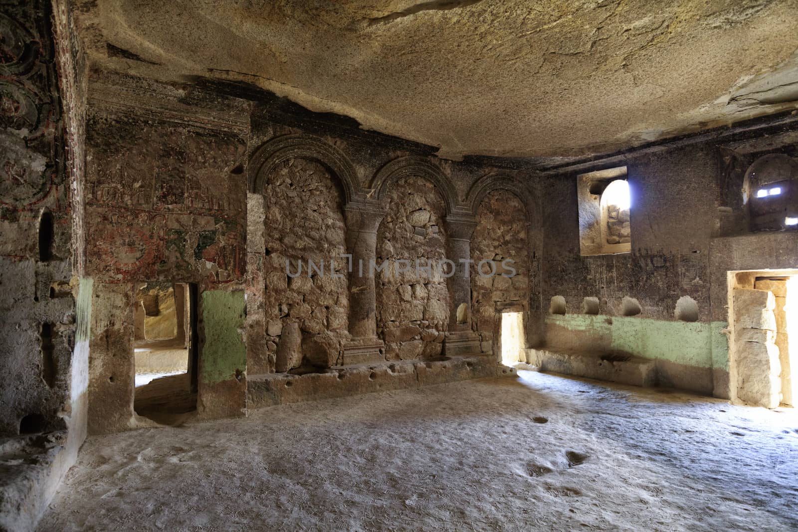 Ancient frescoes on the ruins of the stone walls of an antique church hollowed out of an old sandstone rock in the valley of Cappadocia