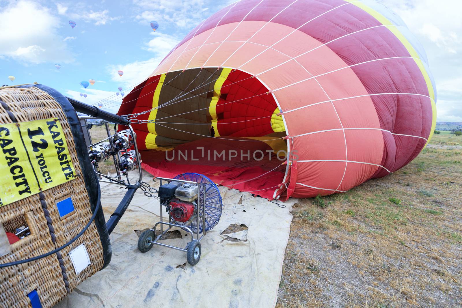 People inflate balloons with a gas torch and a large-capacity gasoline industrial fan by tilting the transport basket to the side.