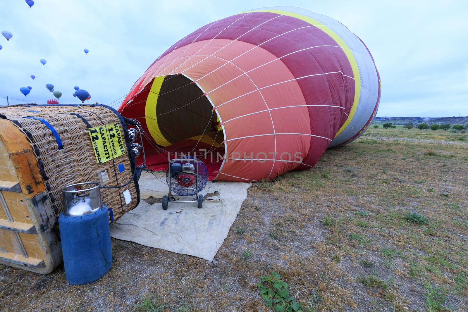People inflate balloons with a gas torch and a large-capacity gasoline industrial fan by tilting the transport basket to the side.