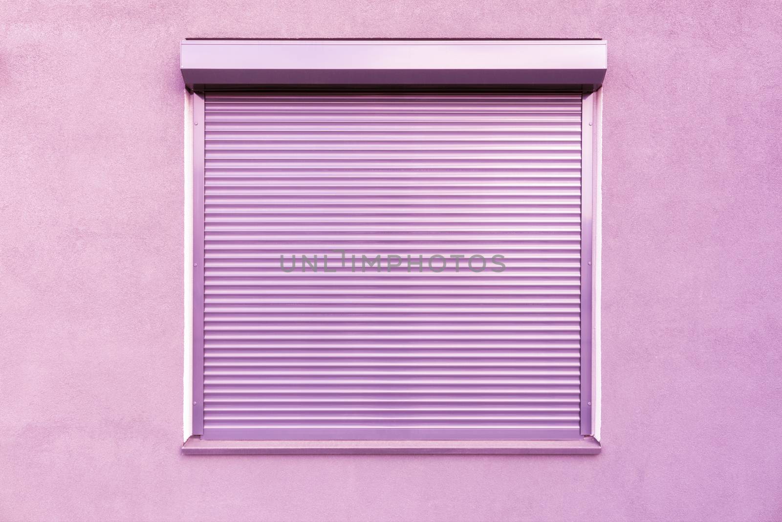 Light pink metal blinds on the windows of the facade of the house.