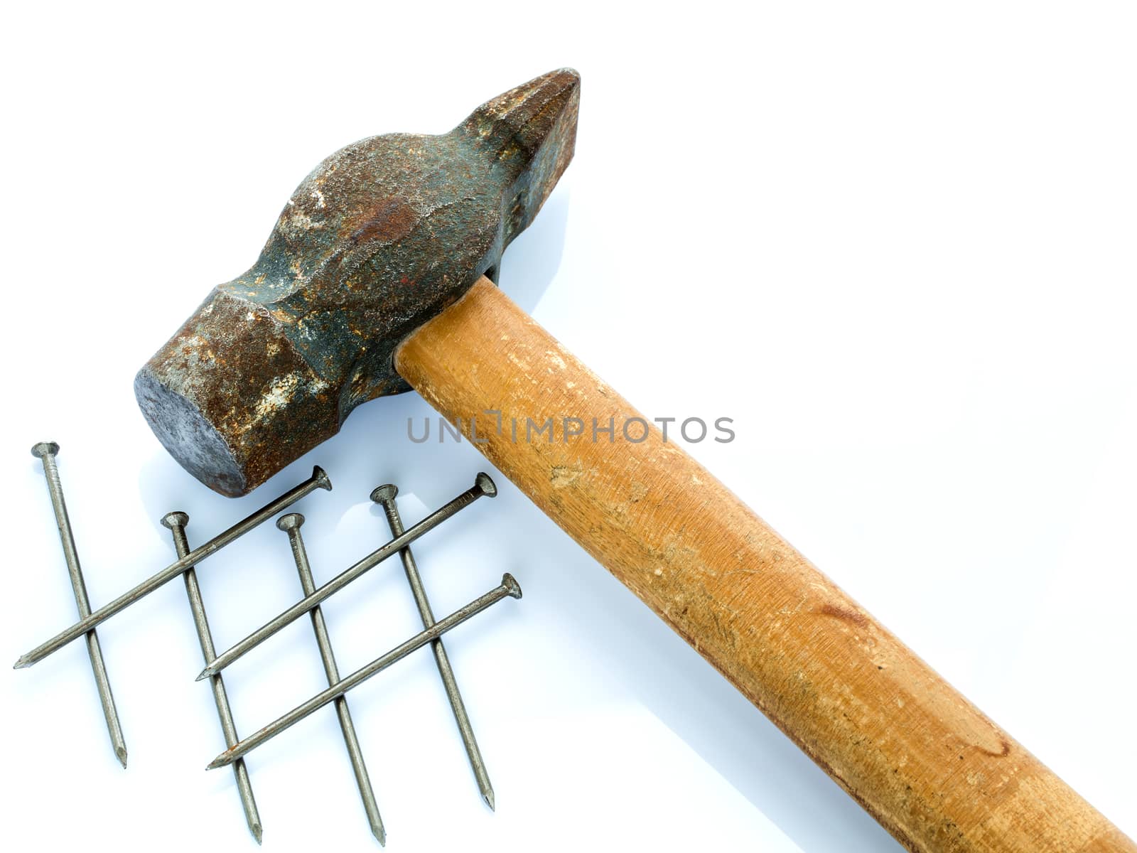 An old hammer with a wooden handle and a bunch of nails. Objects on a light background